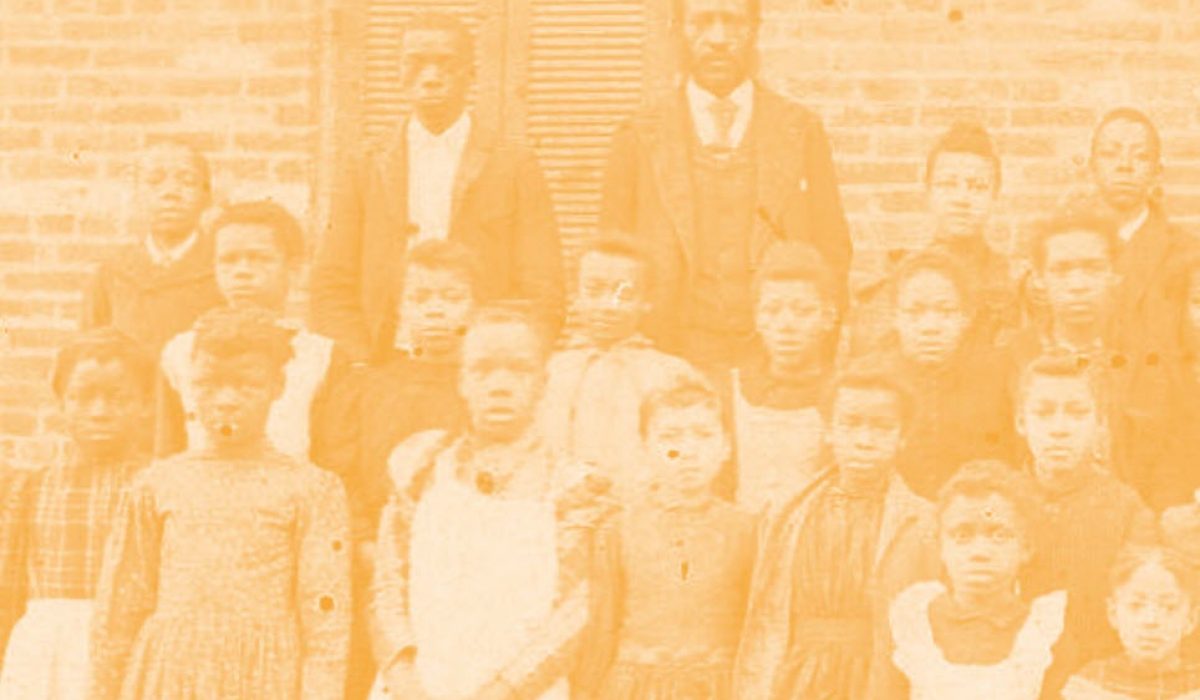 old image of african american school children standing for class photo with an orange filter over the image